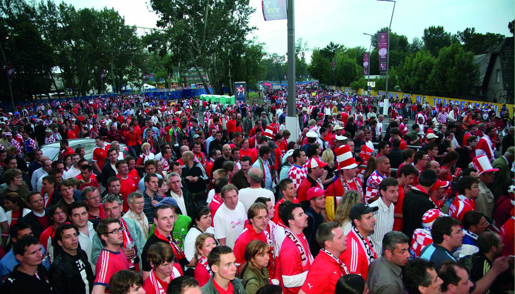 Menschenmenge die rote Trikots und Hüte tragen
